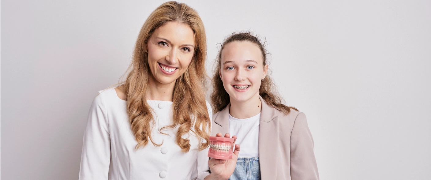 Orthontist with happy patient showing brackets